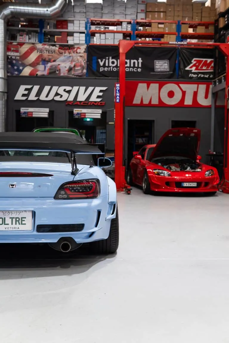A Honda S2000 on the hoist in the workshop